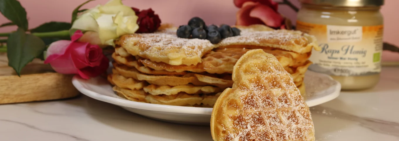 Honig-Waffelherzen auf einem Teller, garniert mit Heidelbeeren