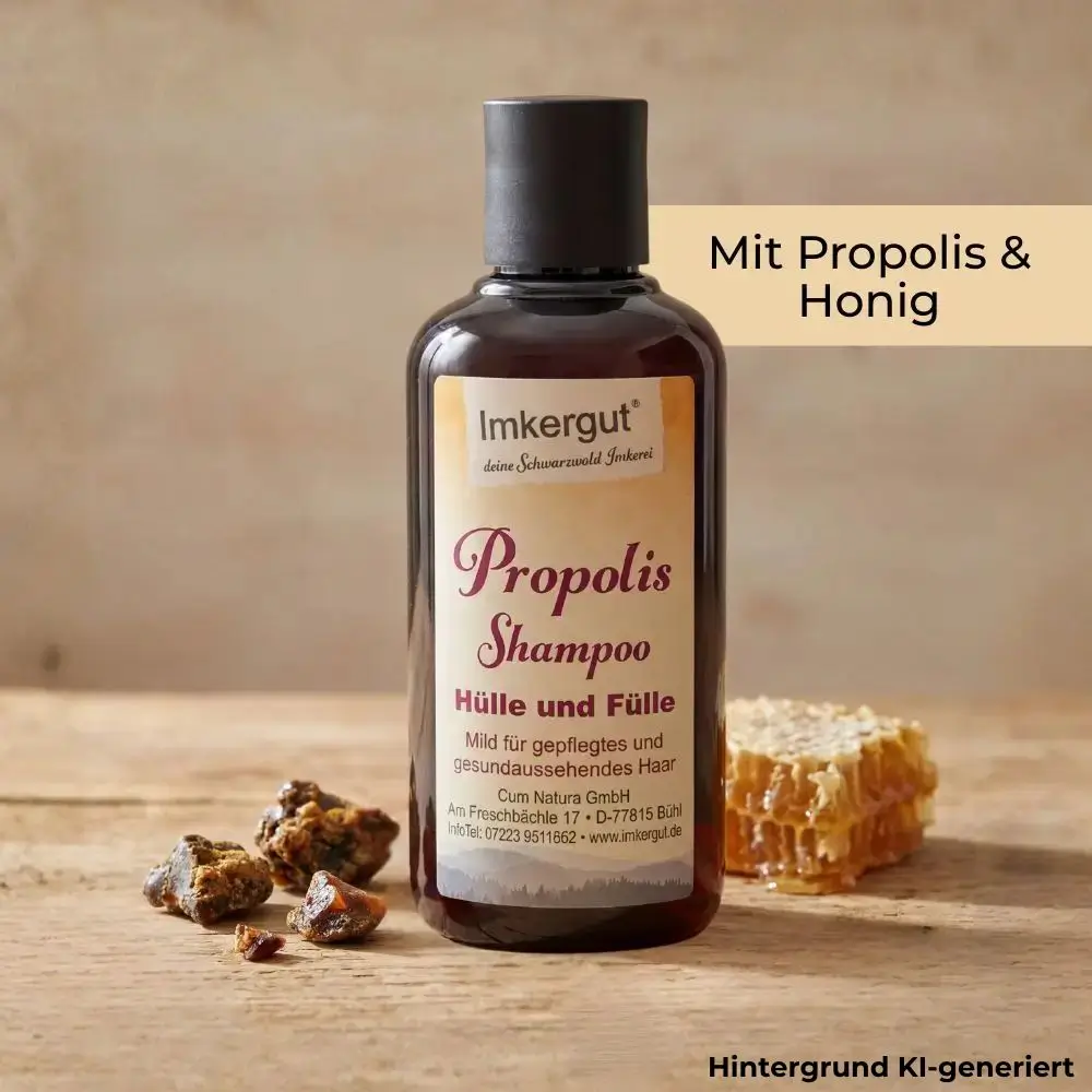Eine Flasche Propolis Shampoo steht auf einem Holztisch neben Propolisstücken und einer Honigwabe, im Bild steht der Text „Mit Propolis & Honig“