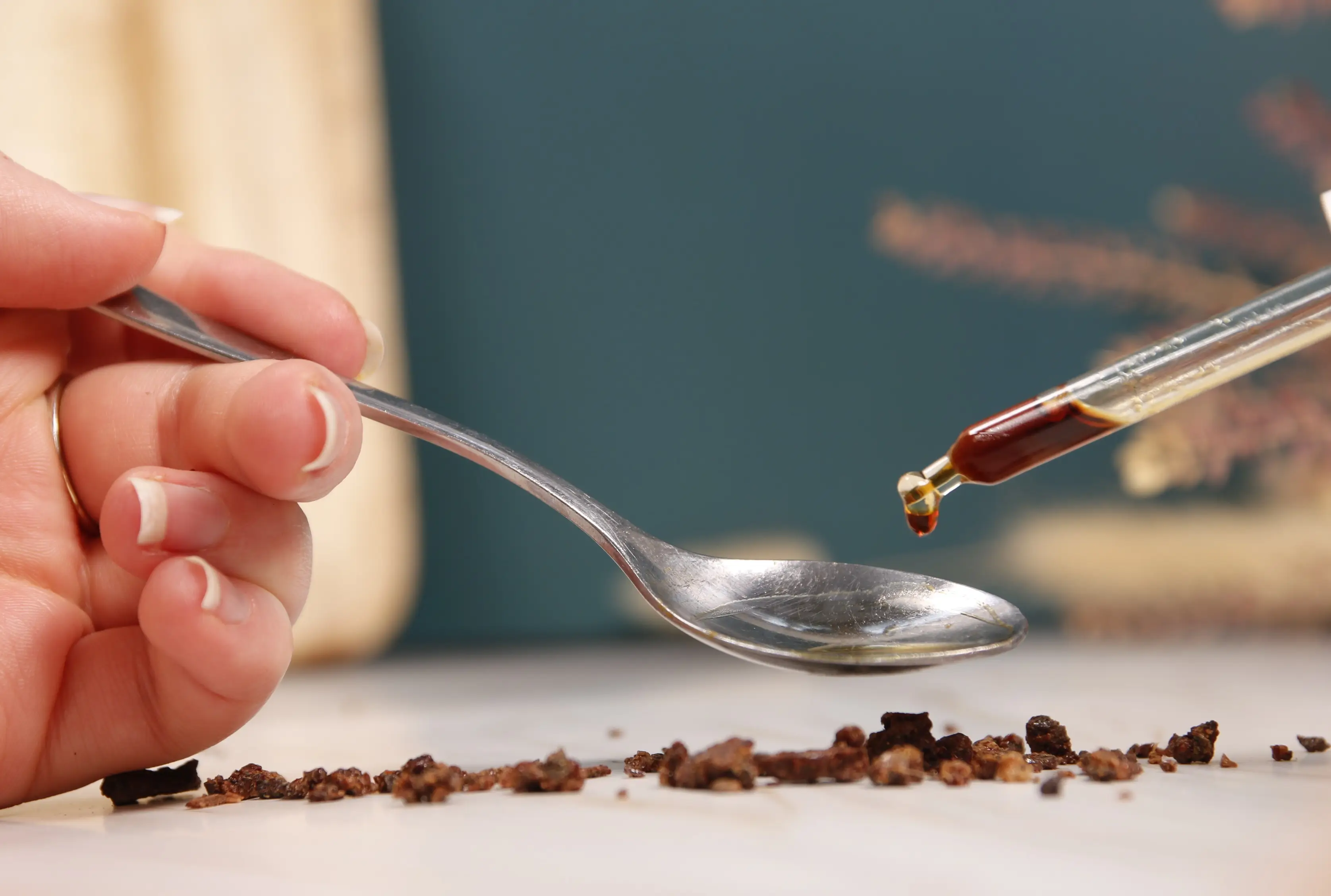 Anwendung von Propolis in Form von Tropfen Propolis-Tropfen werden mit einer Pipette auf einen Löffel getropft