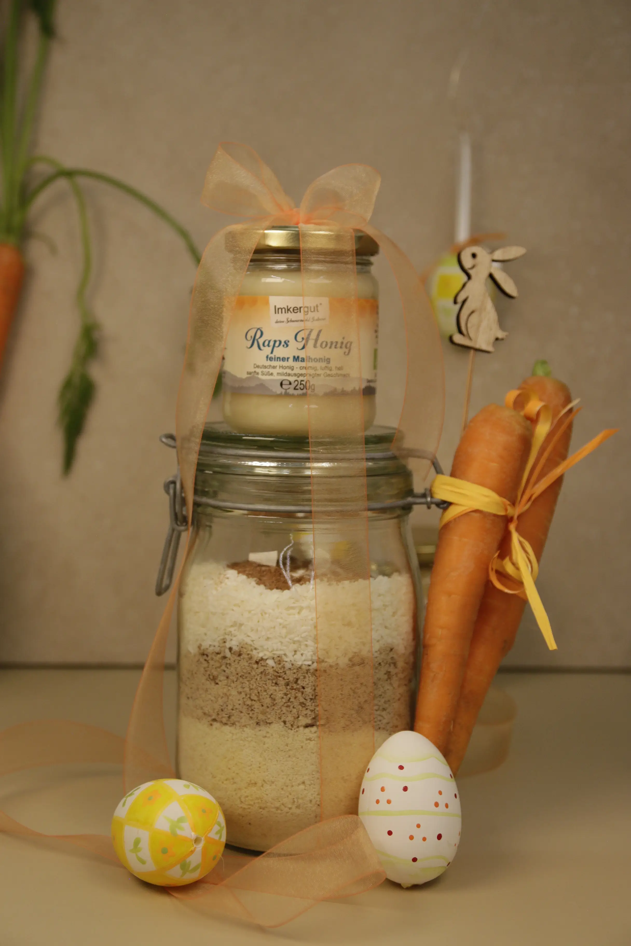 Mandeln, Haselnüsse, Koskosrapsel, Zimt in ein Glas geschichtet, dazu zwei Möhren und ein Glas Honig.