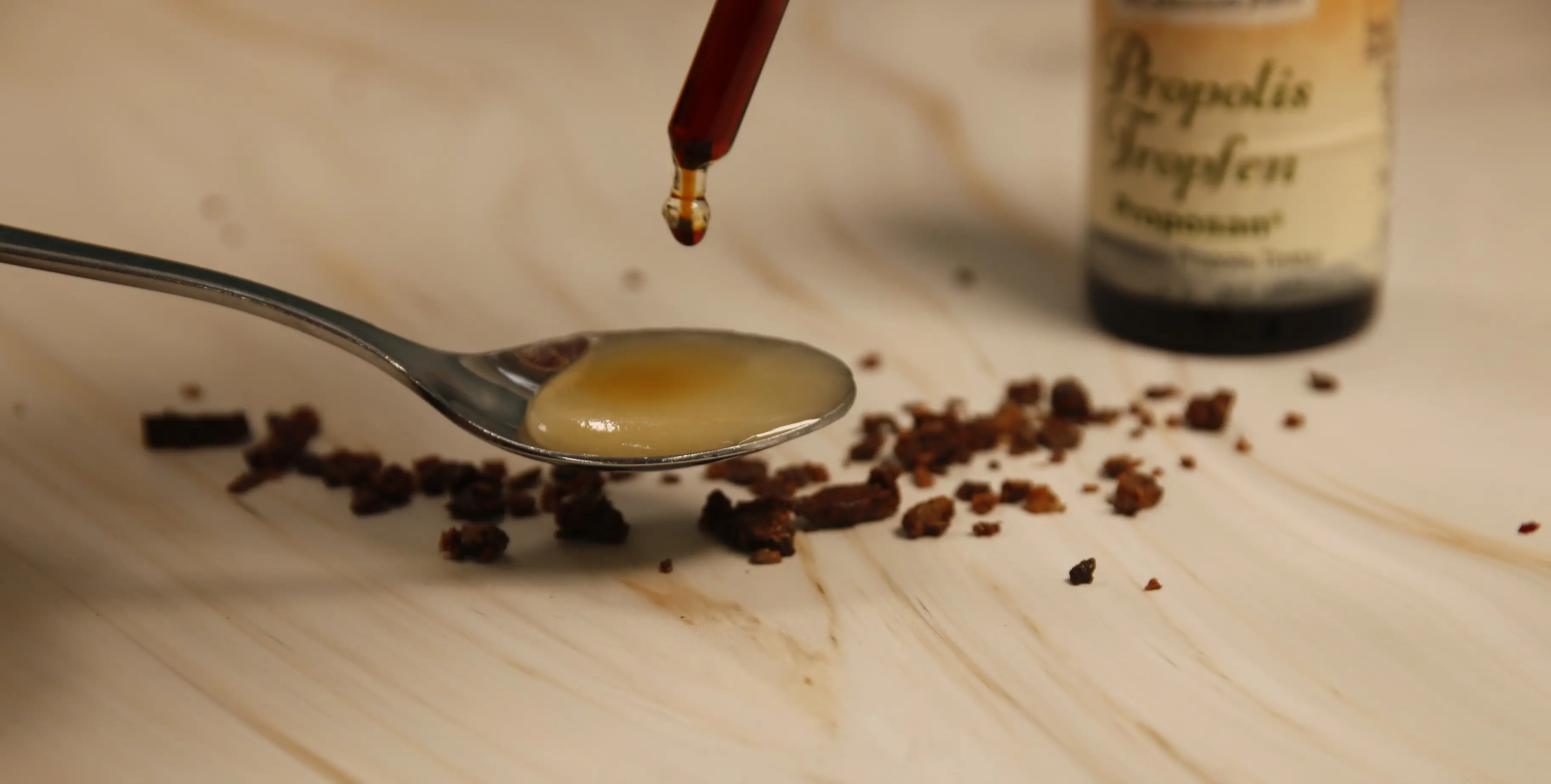 Propolis-Tinktur auf Honig Propolis-Tinktur wird auf einen Löffel mit Honig geträufelt