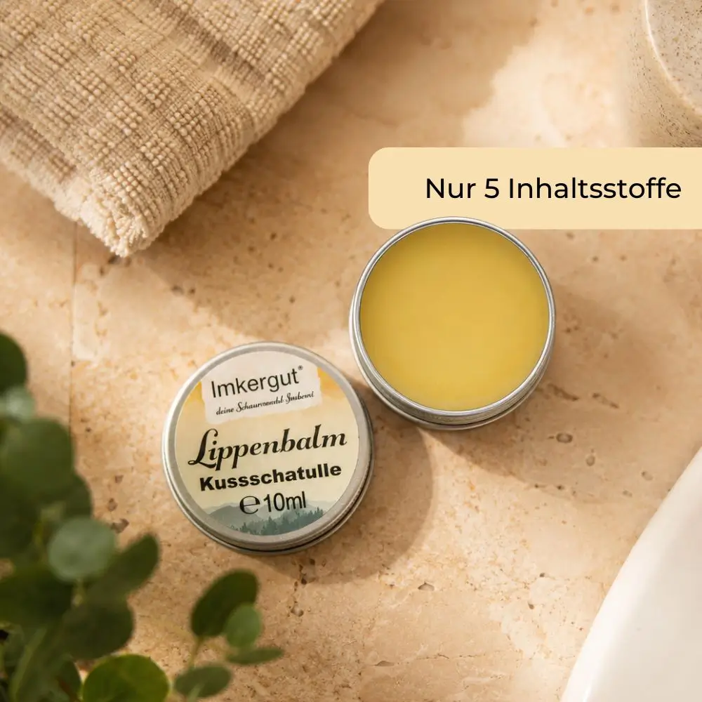Imkergut Lippenbalsam Kussschatulle mit geöffneter Dose auf warmem Steinuntergrund in natürlichem Badezimmer-Ambiente.