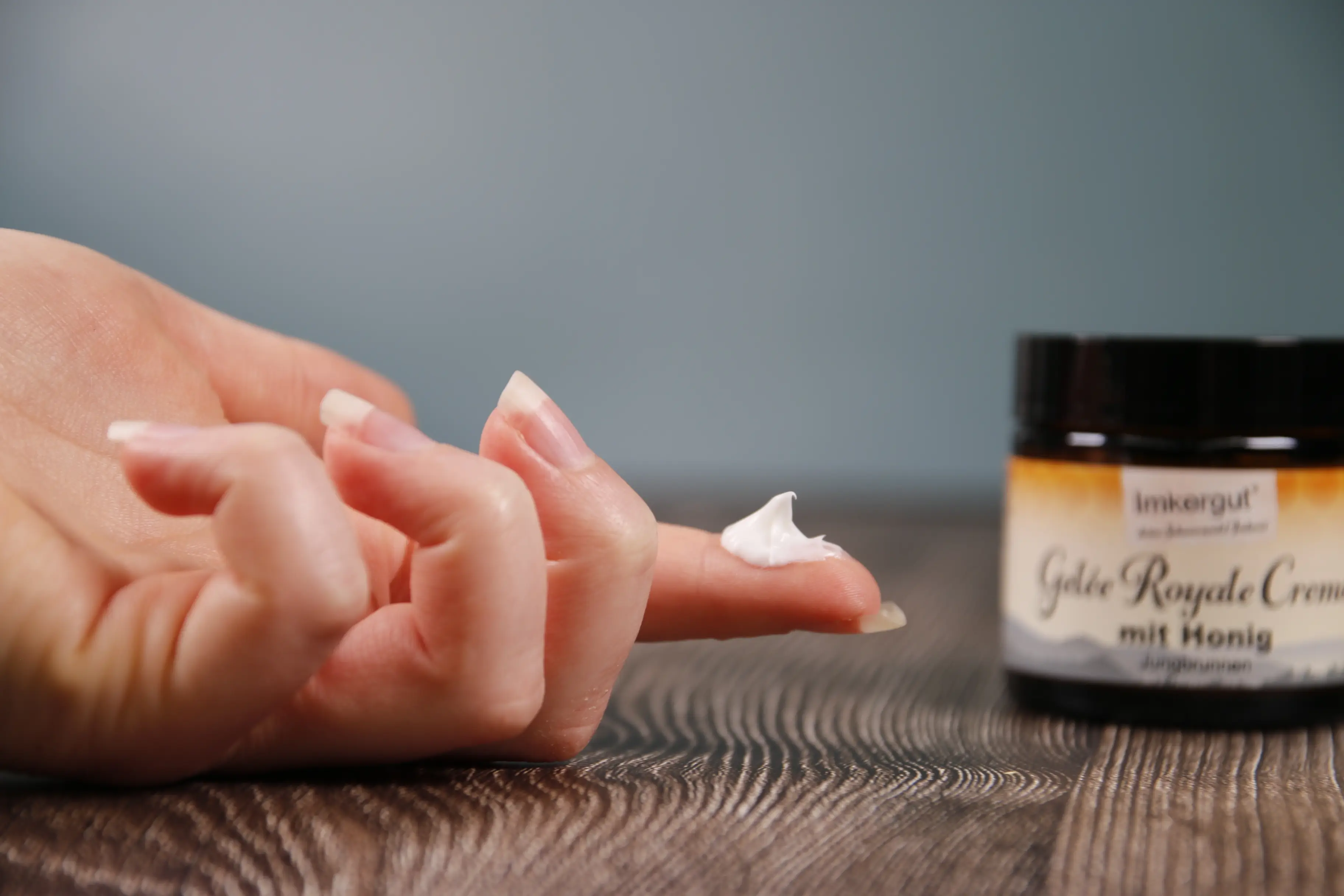 Gelée-Royale-Creme auf der Hand Gelée Royale Creme auf einem Finger, daneben der Tiegel