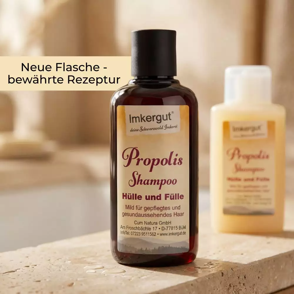 Braune Propolis Shampoo Flasche von Imkergut auf einer Steinoberfläche im Badezimmer, im Vordergrund scharf dargestellt. Im Hintergrund unscharf die ältere, hellere Flasche. Im Bild steht der Text „Neue Flasche – bewährte Rezeptur“.