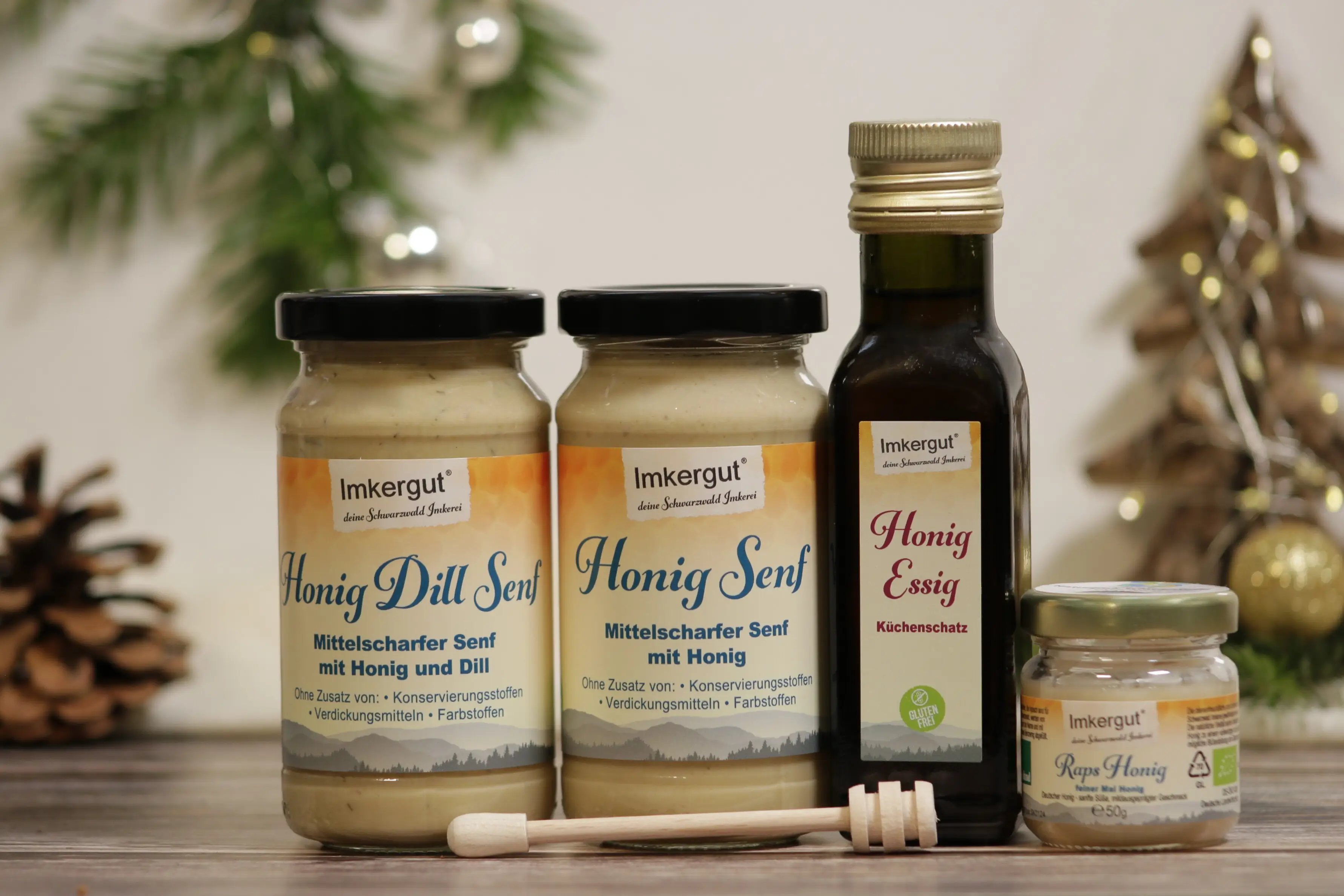 Honig-Dill-Senf, Honigsenf, Honig-Essig und Rapshonig nebeneinander aufgereiht, davor liegend ein kleiner Holz-Honiglöffel