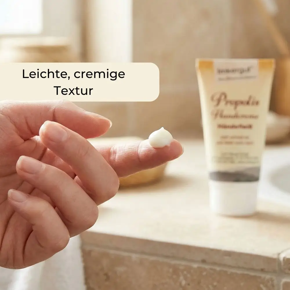 Feine cremige Textur der Handcreme auf dem Finger im Badezimmer, zeigt leichte Konsistenz und einfache Anwendung